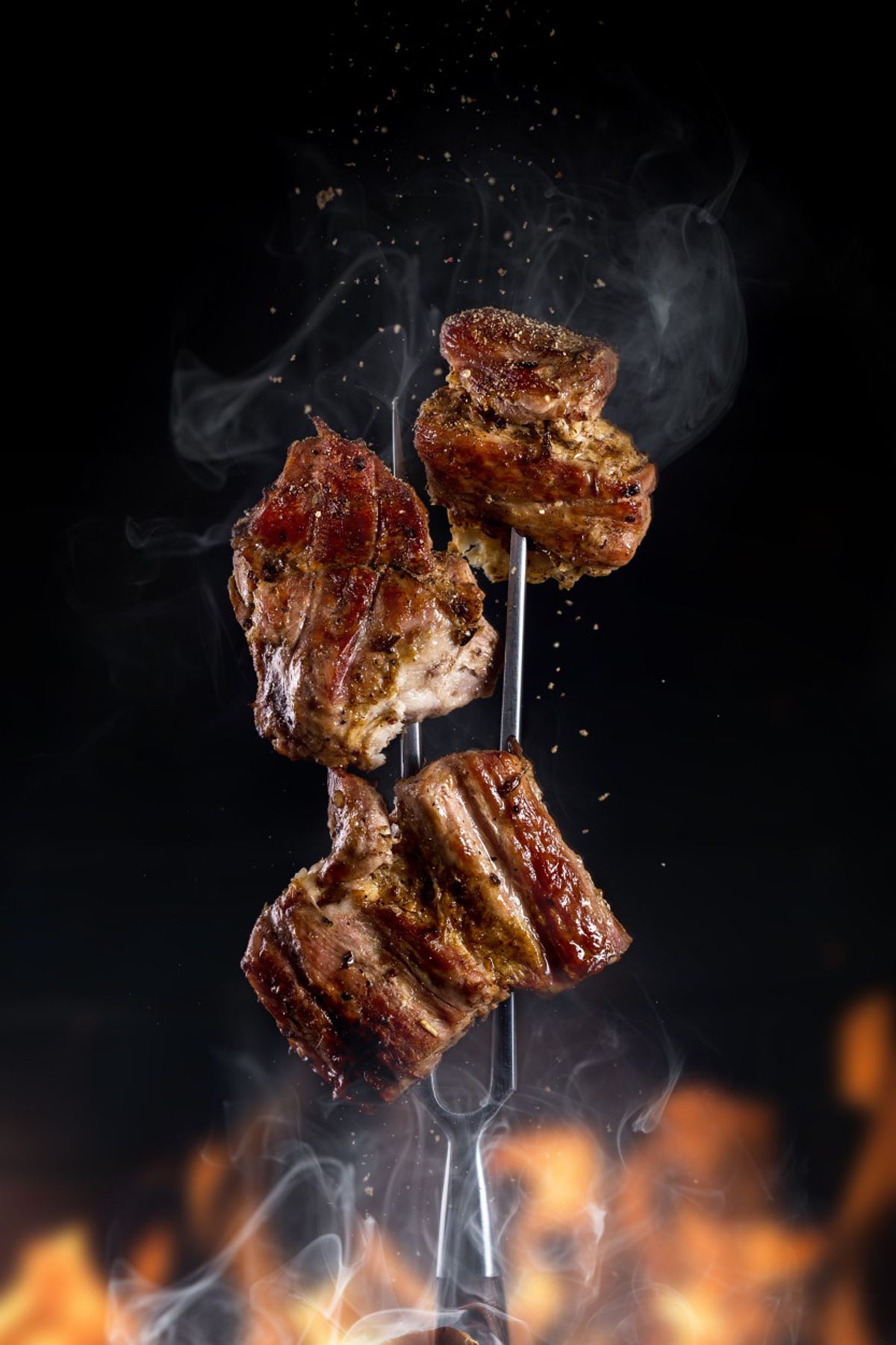 fork-with-pieces-delicious-barbecued-meat-black-background